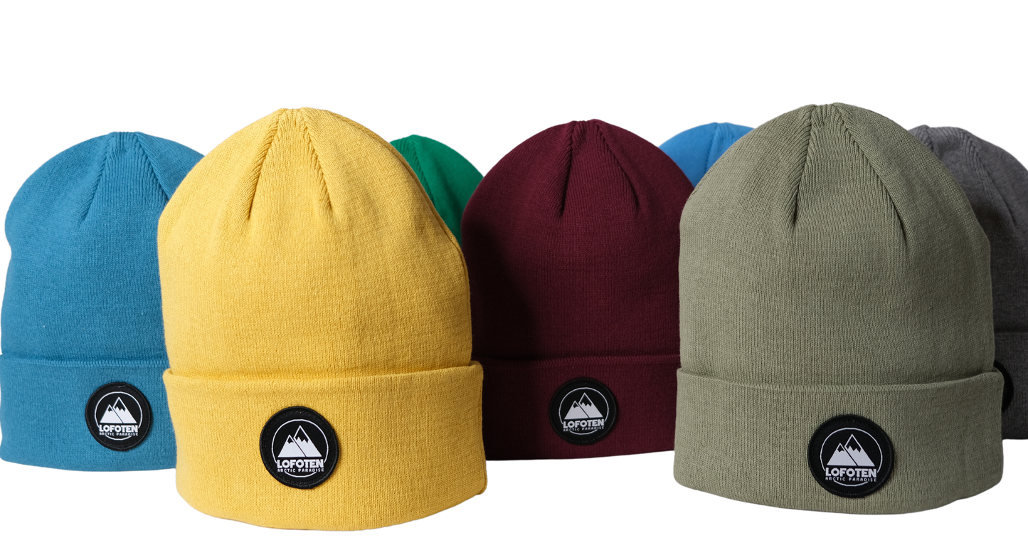 Seven Lofoten beanies in different colors, round Lofoten logo.