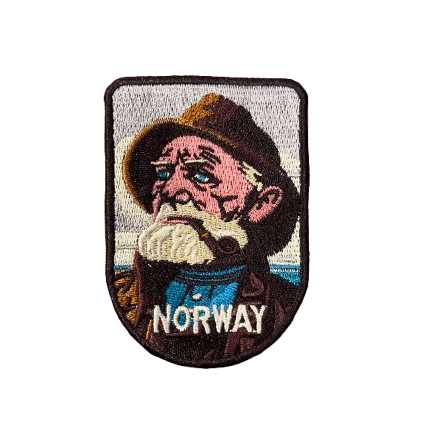 Patch in brown and blue colors with a fisherman smoking his pipe. He has a big beard and a rain hat. Text says Norway.