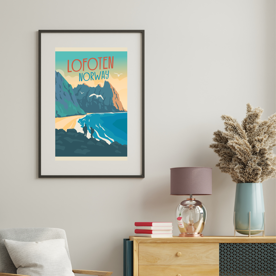 Framed poster of Kvalvika beach in Lofoten, Norway on a wall above a wooden cabinet with decorative items.