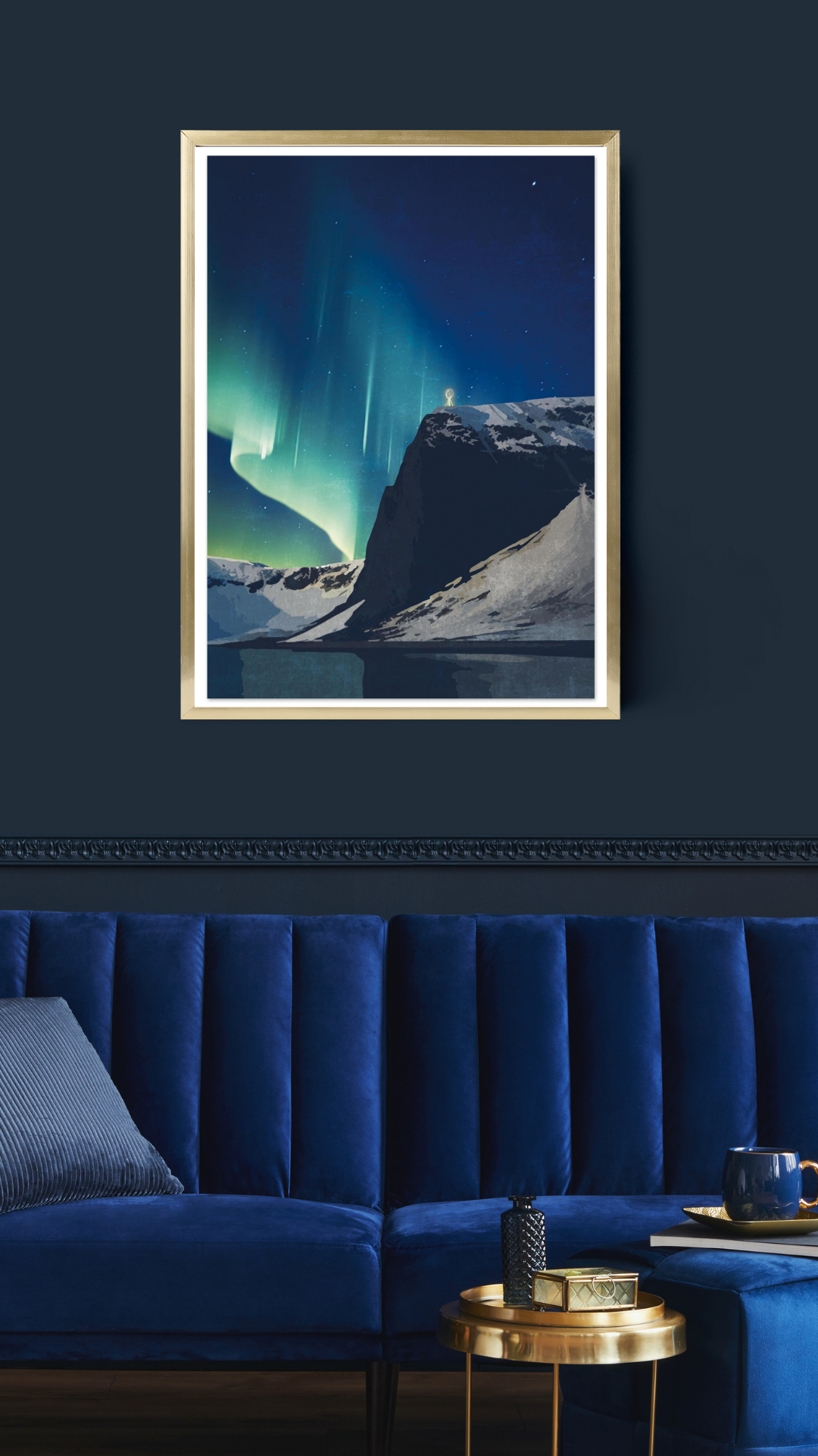 Framed artwork of the North Cape plateau with Northern Lights above, displayed on a dark blue wall above a blue sofa.