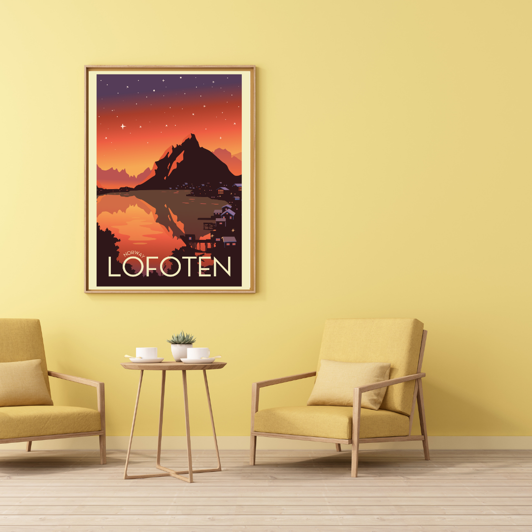 Framed artwork of Reine in Lofoten on a yellow wall with two chairs and a small table.