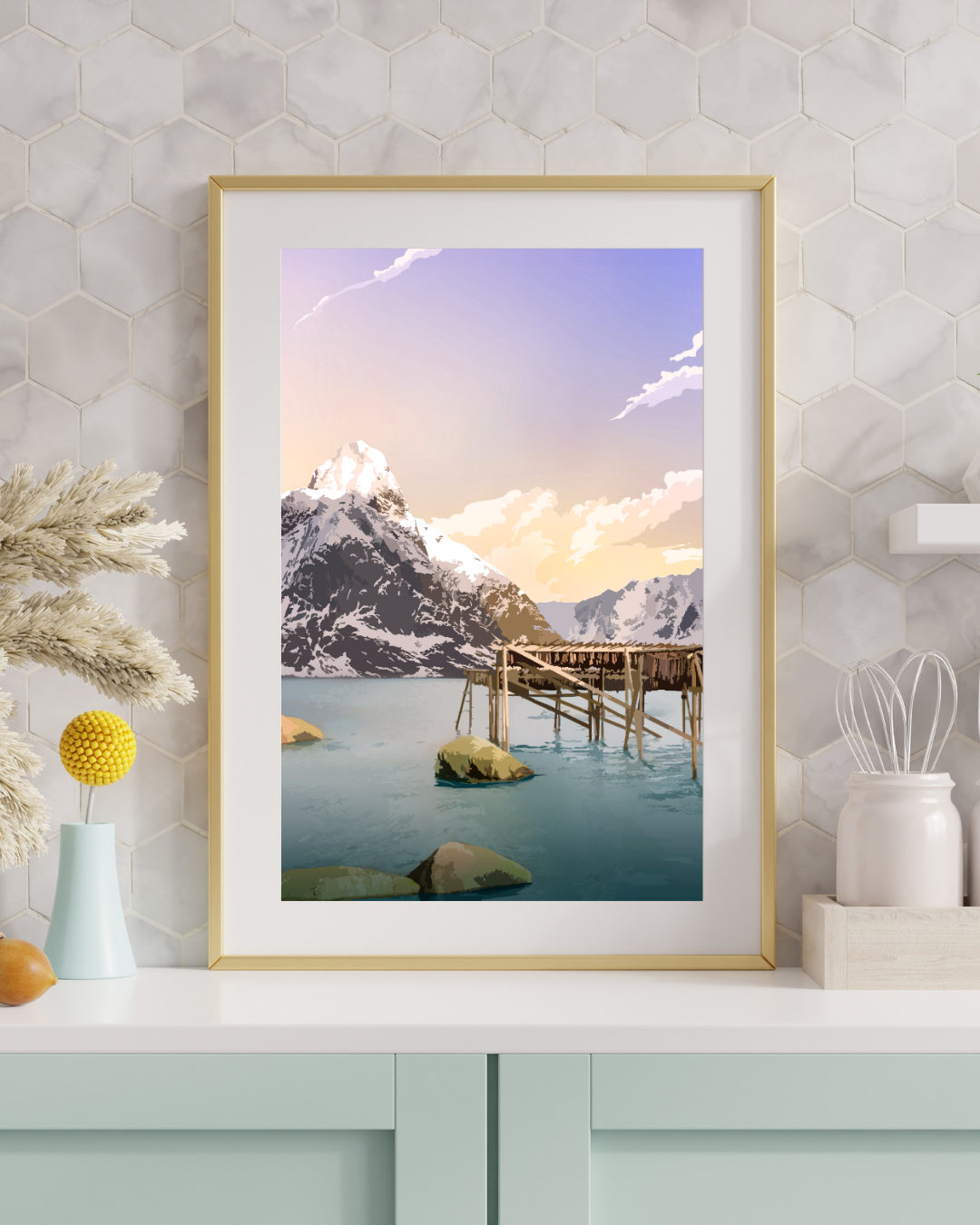 Framed mountain landscape from Lofoten with the stockfish racks in the front. The print ison a wall with decorative elements.