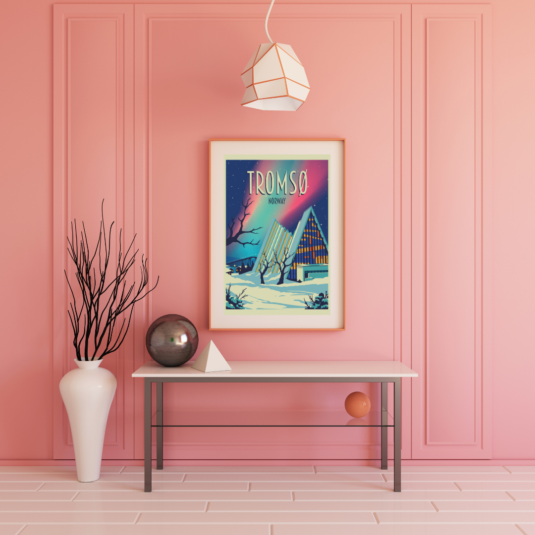 Framed artwork on a pink wall with a table and decorative items. Picture is from the church Ishavskatedralen in Tromsø. The sky is lighten up by northern light in green and pink.