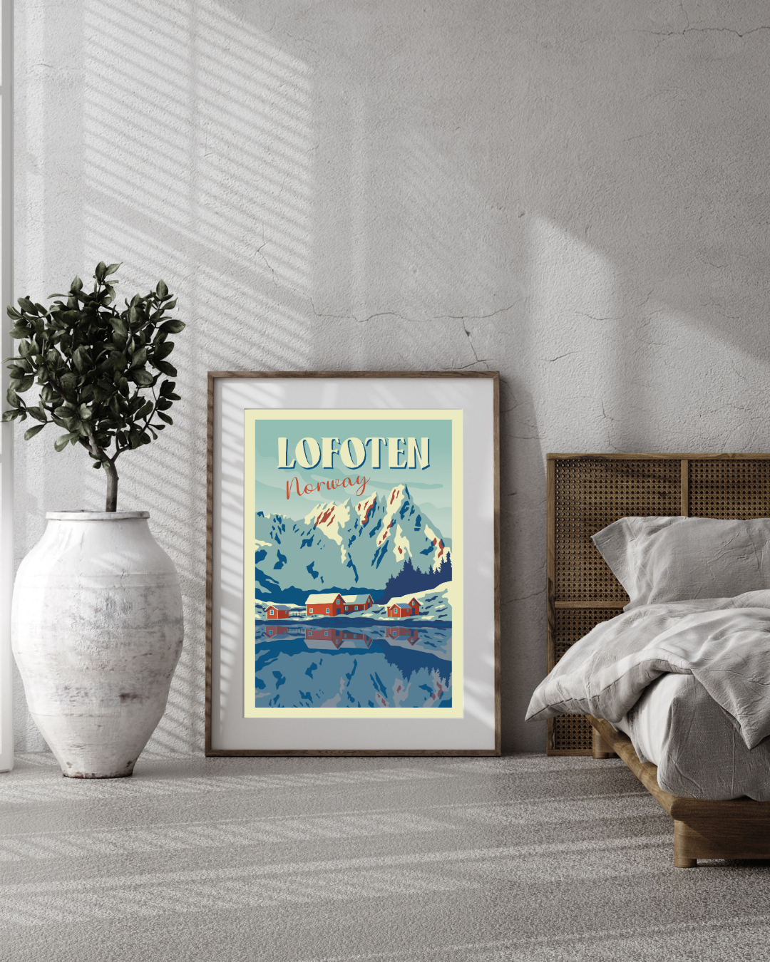 Framed artwork from Ballstad and the mountain Skottind in Lofoten, Norway in a bedroom setting with a bed and plant.