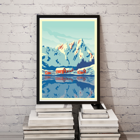 Framed winter picture from Ballstad in Lofoten. Colors are white, blue and red. In the picture there are high mountains in the back, red cabins in the middle and the bkue ocean in the front. 