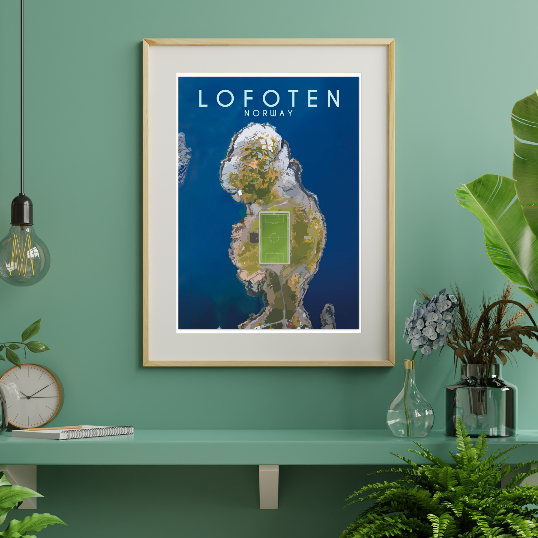 Framed artwork from the soccer field in Henningsvær in Lofoten, Norway on a green wall with plants and decor.