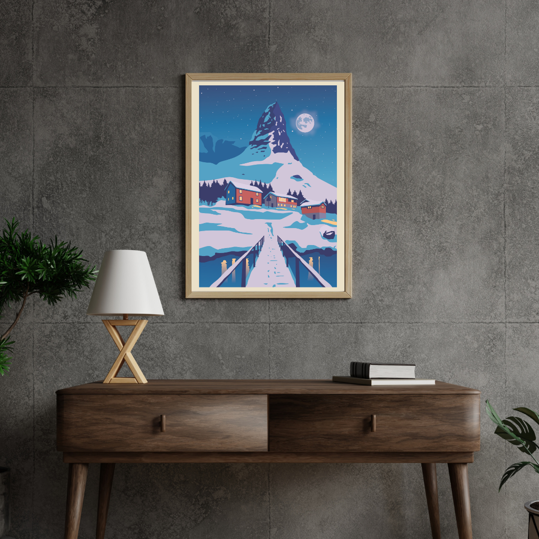 Framed artwork of a snowy mountain scene above a wooden console table with a lamp and books. Mountain is Hammarskaftet in Reine, Lofoten. Full moon behind the snowy mountain. 