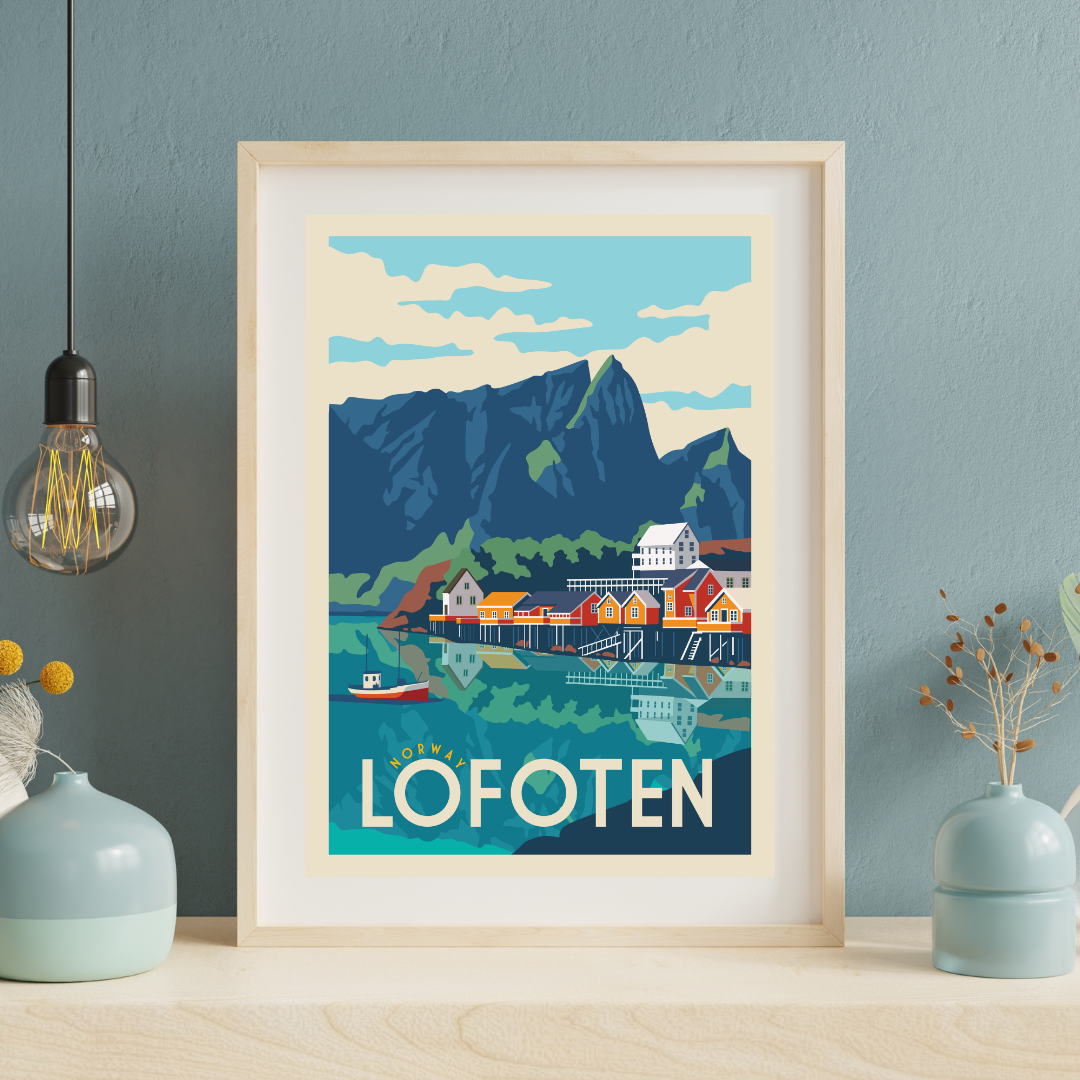 Framed artwork of Lofoten with mountains, water, and fisherman cabins on a blue wall. Classic view over Sakrisøy in Lofoten.