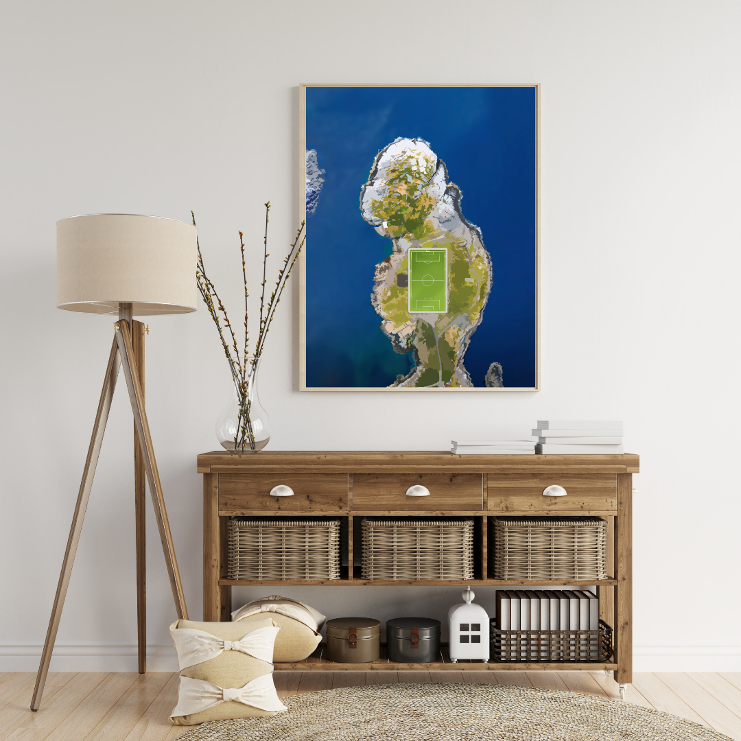 Living room with wooden console table, lamp, and framed artwork on the wall. The poster in the frame is from the famous soccer field in Henningsvær, Lofoten Norway.